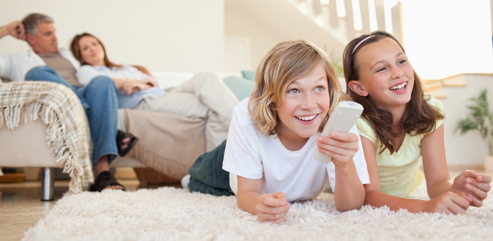 Siblings lying on the floor watching tv together.jpeg